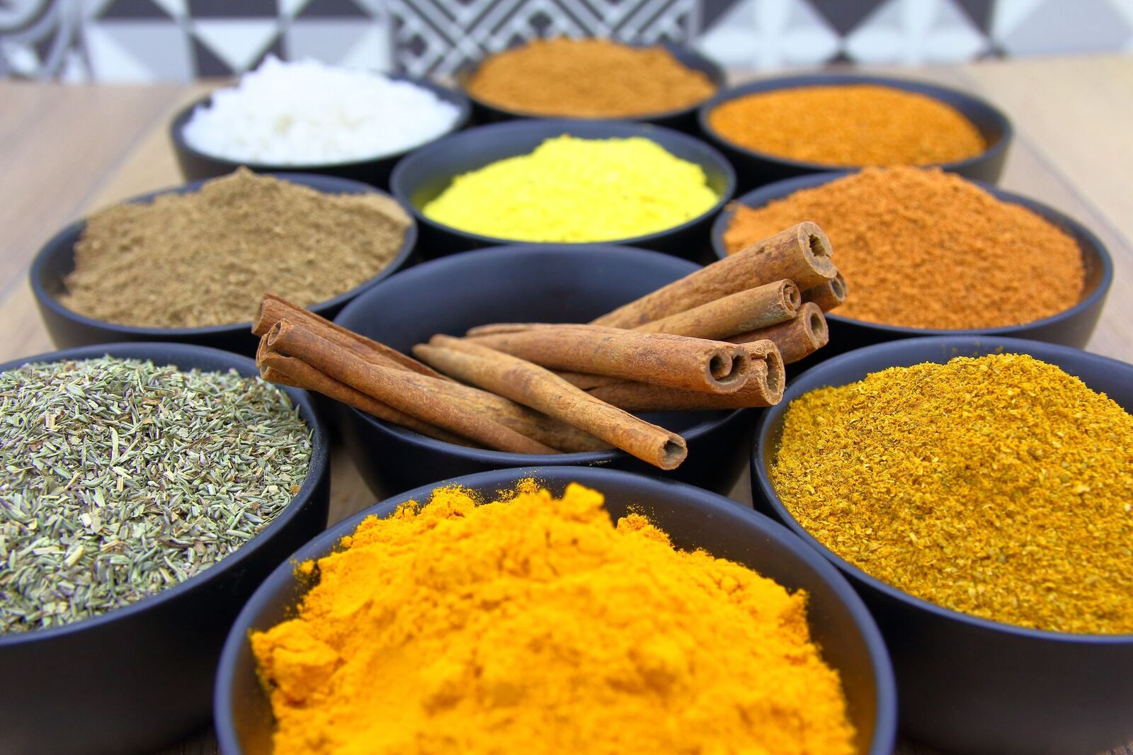 Bowls of ground Indian spices and cinnamon
